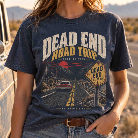 Close-up of a woman wearing the navy Dead End Road Trip shirt with vintage car and highway sign artwork.