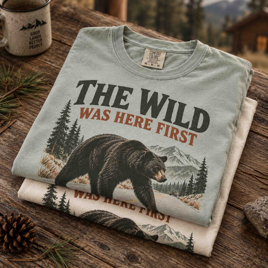 The Wild Was Here First bear wildlife graphic tee shown in a mountain outdoor lifestyle setting