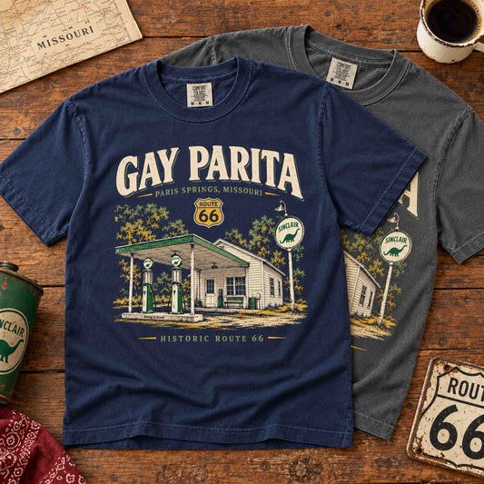 Navy and Pepper Gay Parita Paris Springs Route 66 graphic T-shirts overlapping on a rustic wooden table.