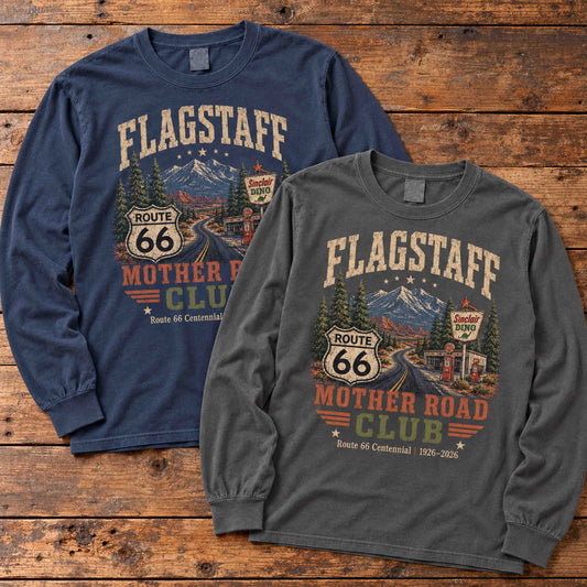 Navy and Pepper Flagstaff Route 66 Mother Road Club long sleeve graphic tees arranged flat on a wooden table.