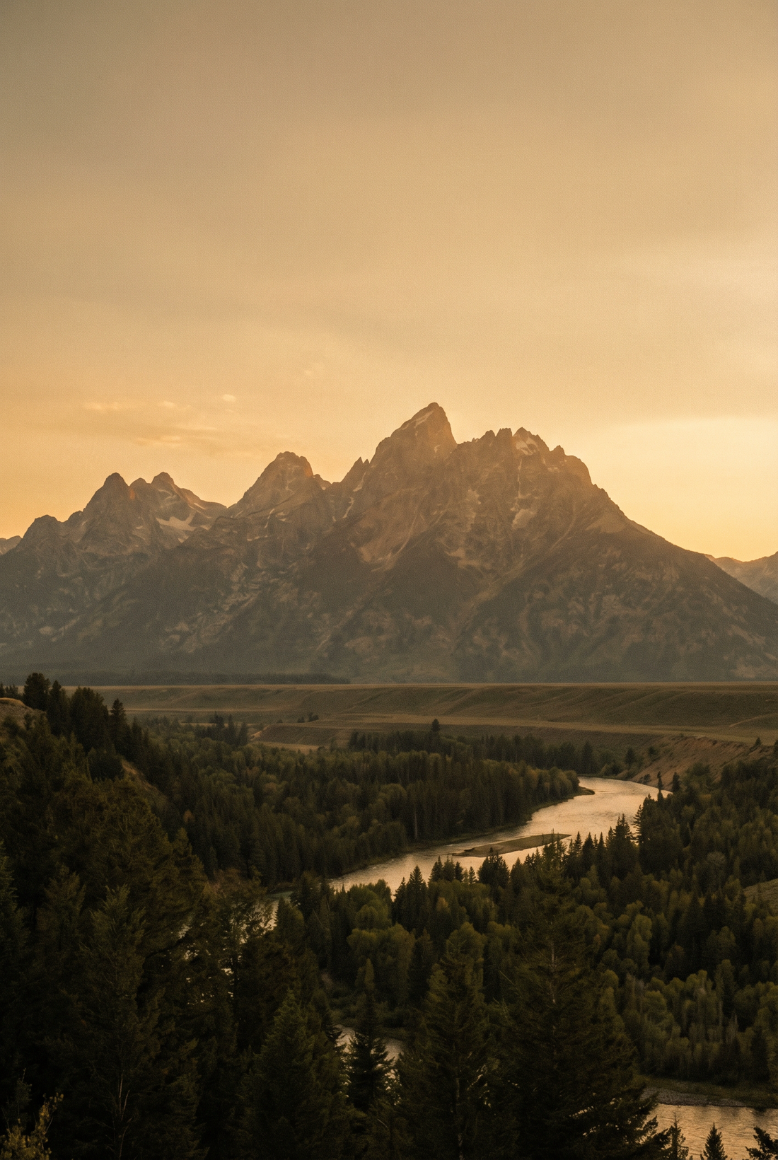 Scenic national park mountain landscape with river, pine trees, and warm golden hour light