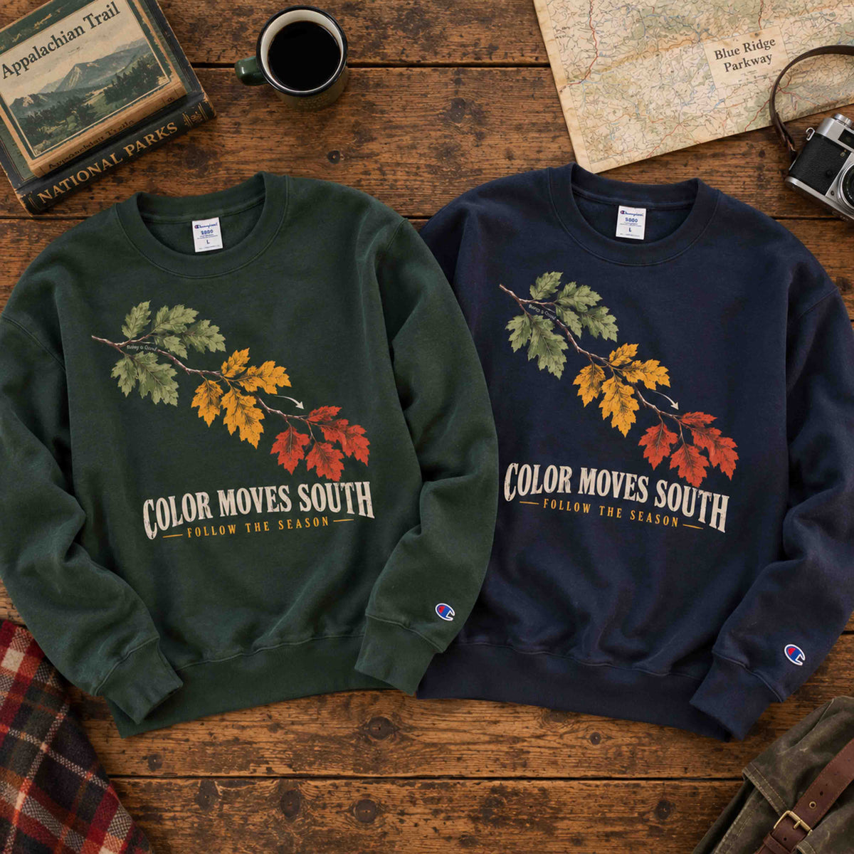 Dark Green and Navy Being is Good Color Moves South sweatshirts laid flat side by side on a wooden table.