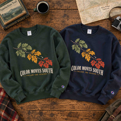 Dark Green and Navy Being is Good Color Moves South sweatshirts laid flat side by side on a wooden table.