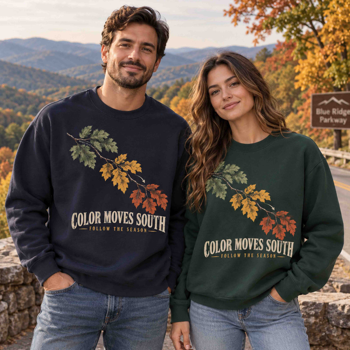 Two adults wearing Being is Good Color Moves South sweatshirts in Navy and Dark Green at an autumn mountain overlook.