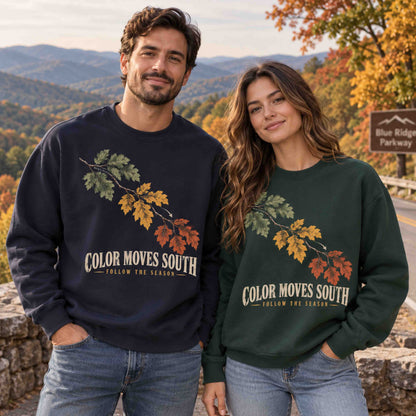 Two adults wearing Being is Good Color Moves South sweatshirts in Navy and Dark Green at an autumn mountain overlook.