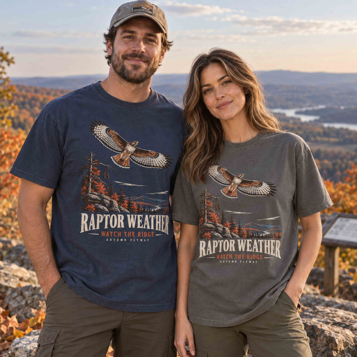Couple wearing Navy and Pepper Raptor Weather Autumn Flyway graphic tees at a mountain ridge overlook in fall