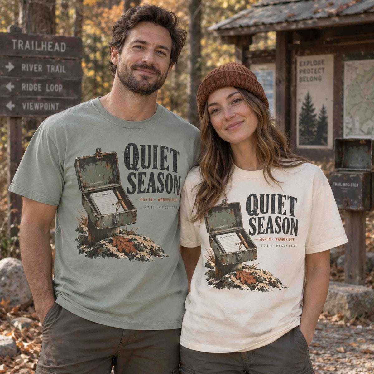 Couple wearing Bay and Ivory Quiet Season Trail Register graphic tees at an autumn hiking trailhead