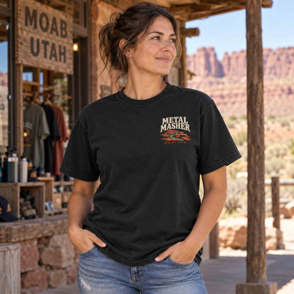 Woman wearing a Black Metal Masher tee with the small left-chest trail graphic outside a desert shop.