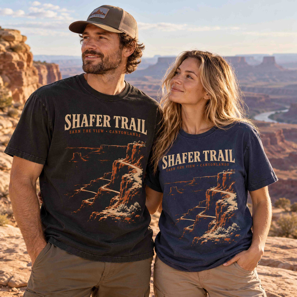 Couple wearing Black and Navy Shafer Trail Canyonlands graphic T-shirts at a Utah canyon overlook.