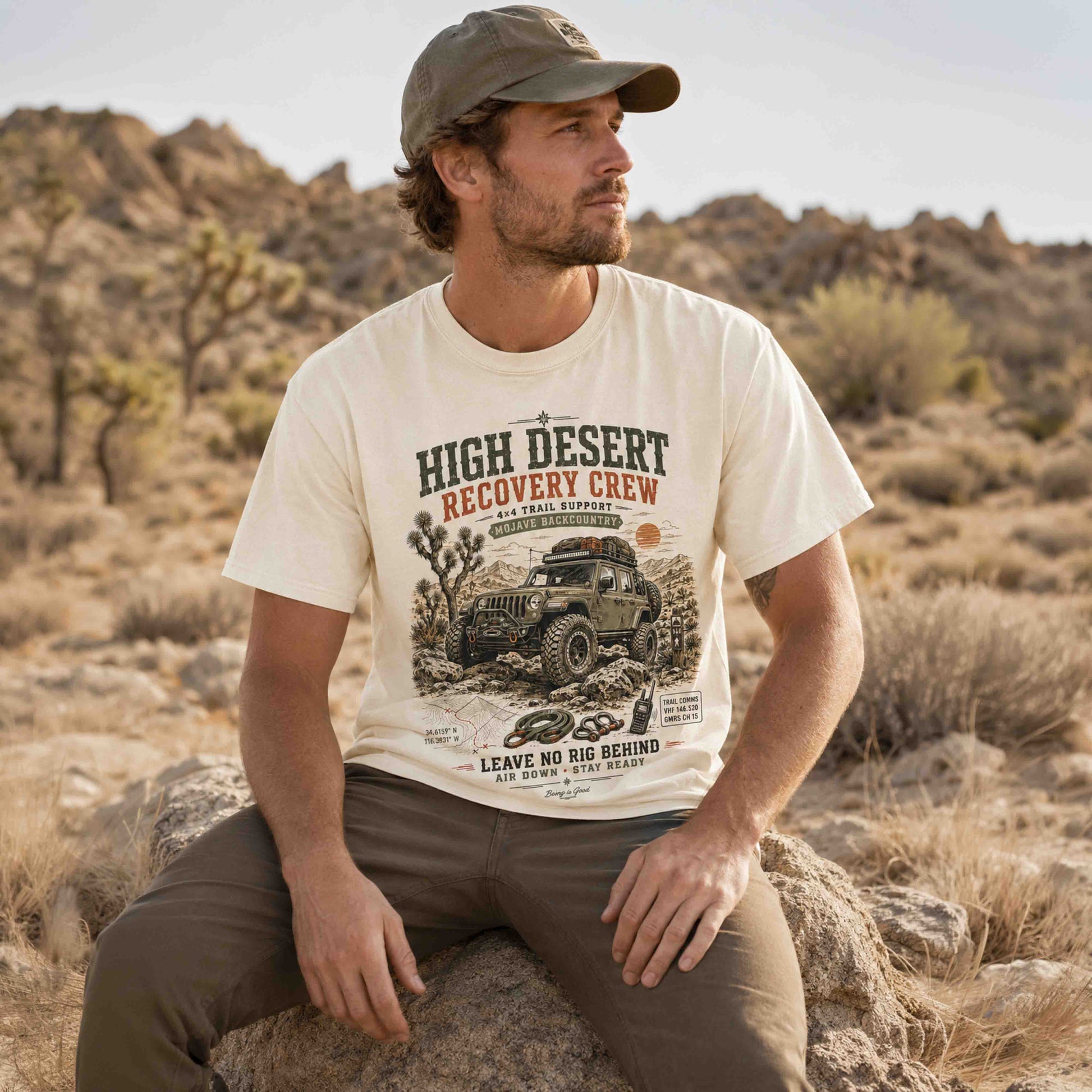 Seated man wearing a Mojave backcountry recovery crew graphic T-shirt