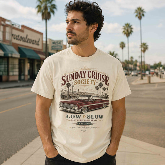 Man wearing an Ivory Sunday Cruise Society Low and Slow graphic T-shirt on a Southern California boulevard