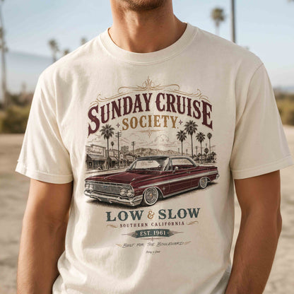 Close-up of Sunday Cruise Society vintage lowrider graphic printed on an Ivory T-shirt