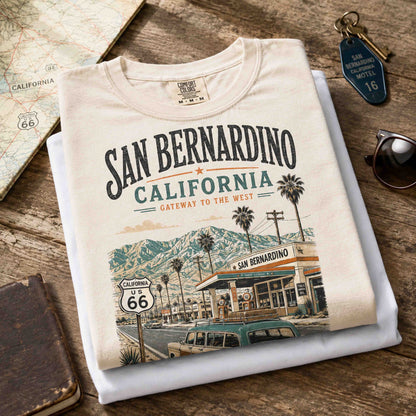Female model wearing ivory San Bernardino California Route 66 graphic tee in a historic roadside setting