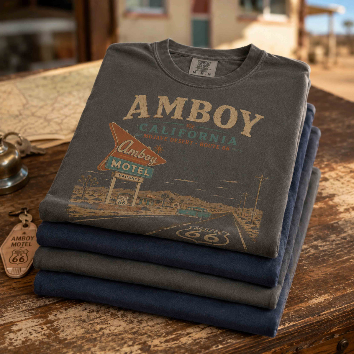 Man and woman wearing Amboy California Route 66 shirts in a vintage Mojave Desert roadside setting.
