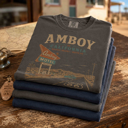 Man and woman wearing Amboy California Route 66 shirts in a vintage Mojave Desert roadside setting.