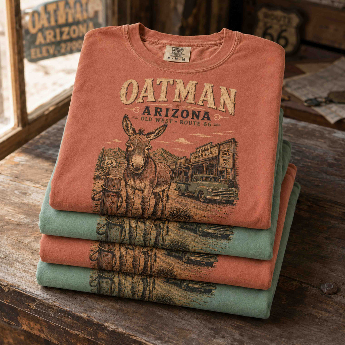 Man wearing a Light Green Oatman Arizona Route 66 graphic tee in an old-west desert town setting.