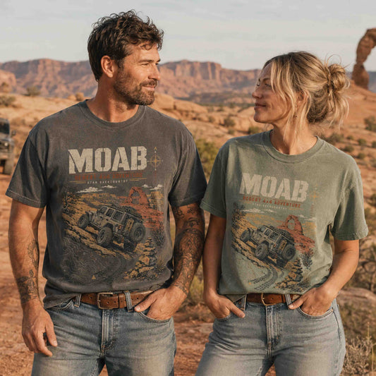 Couple wearing Moab Utah Desert 4x4 Adventure graphic tees in a scenic red rock desert setting.