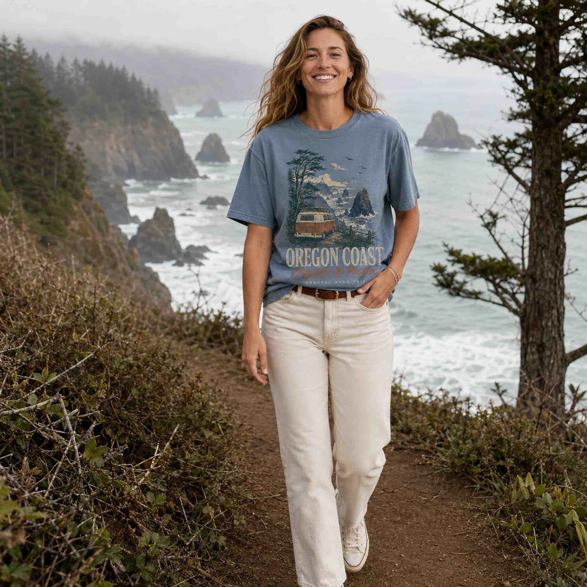 Woman wearing Oregon Coast Chasing the Pacific Road Trip graphic tee on a coastal trail
