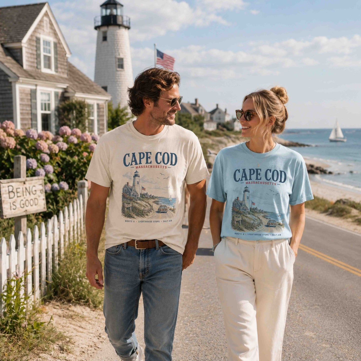 Couple wearing Ivory and Chambray Cape Cod graphic T-shirts on a New England coast