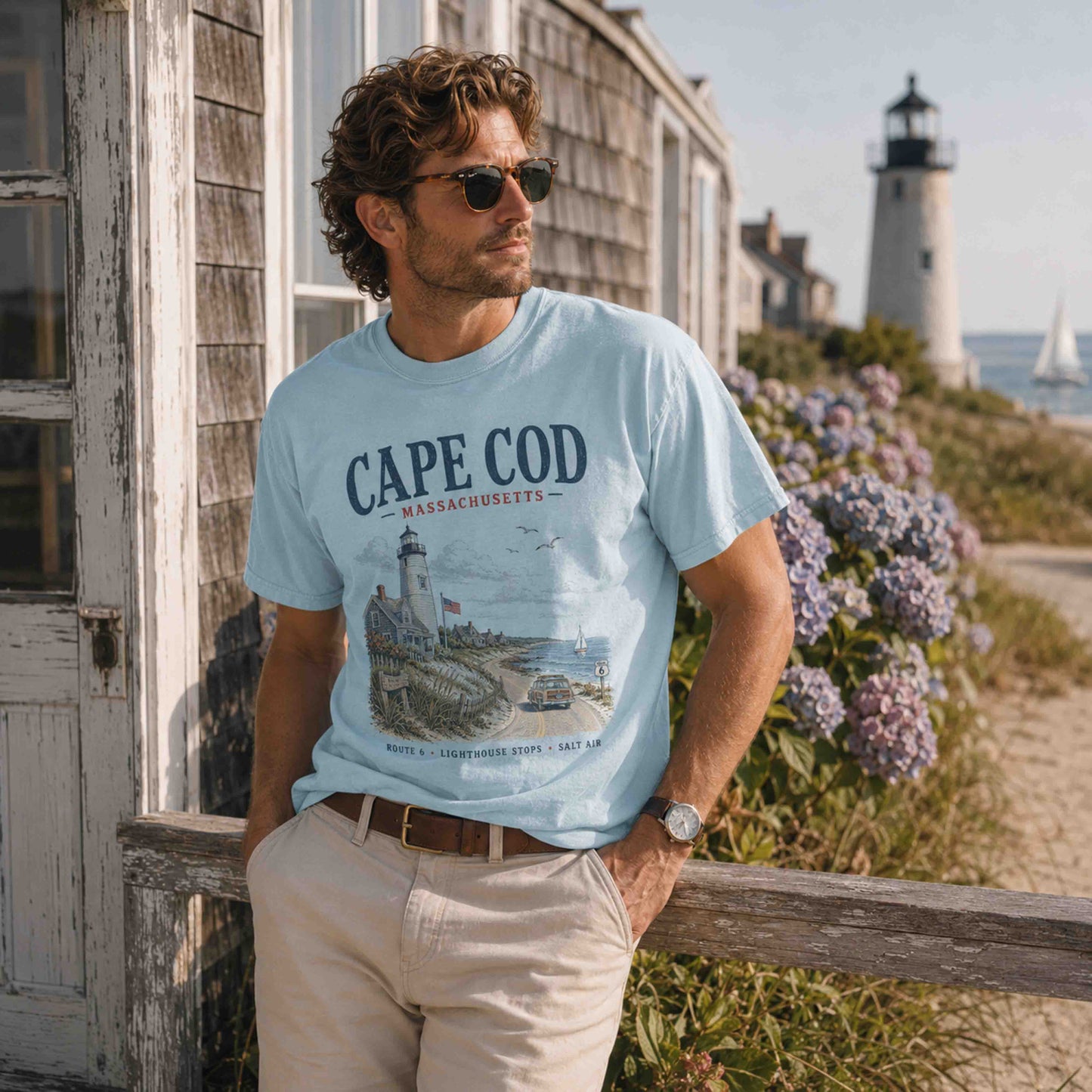 Male model wearing Chambray Cape Cod Massachusetts coastal graphic tee near a lighthouse