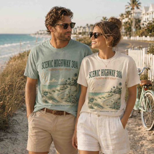 Couple wearing Scenic Highway 30A Florida graphic tees on a white sand beach