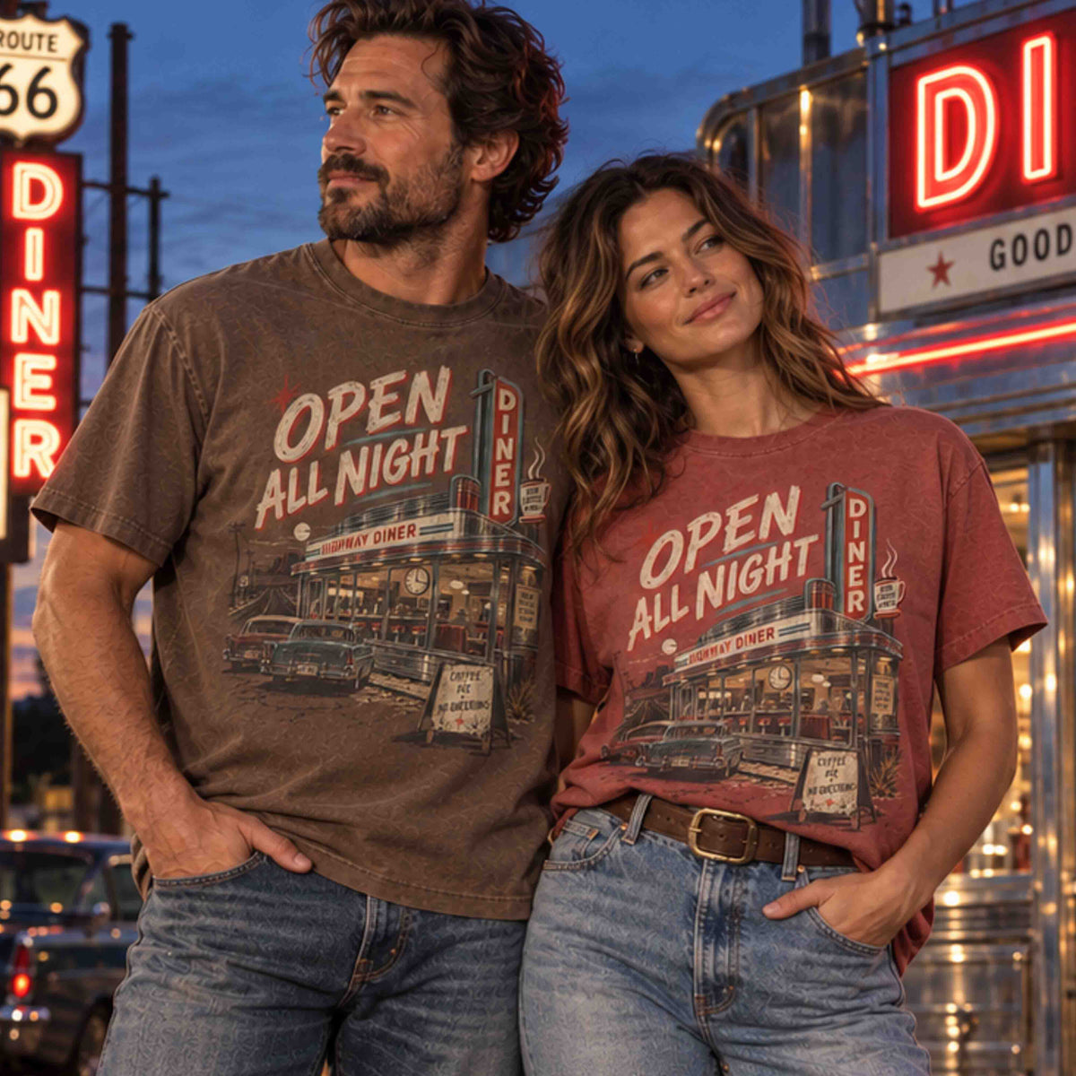 Man and woman wearing Open All Night Diner graphic tees featuring a vintage roadside diner, classic cars and retro Americana artwork.