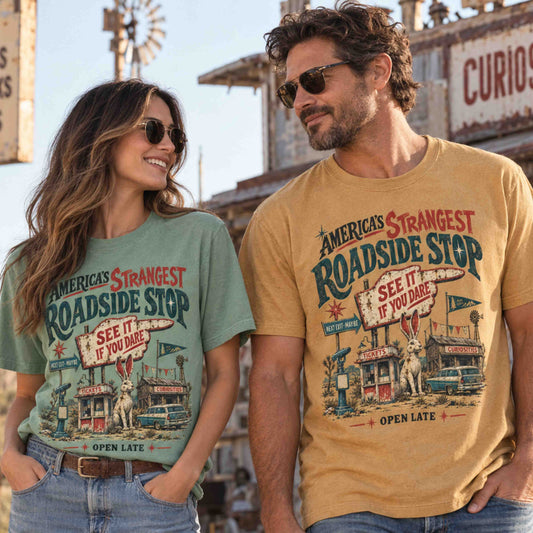 Man and woman wearing America’s Strangest Roadside Stop jackalope graphic tees with vintage cryptid and roadside attraction artwork.