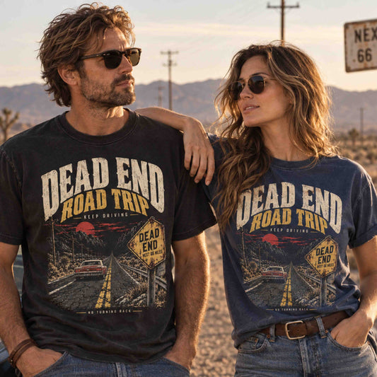 Man and woman wearing black and navy Dead End Road Trip graphic tees featuring a classic car on a desert highway.