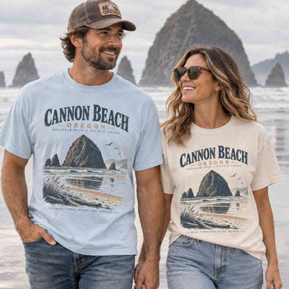 Couple wearing Cannon Beach Oregon graphic tees featuring Haystack Rock and vintage Pacific Coast artwork in Chambray and Ivory.