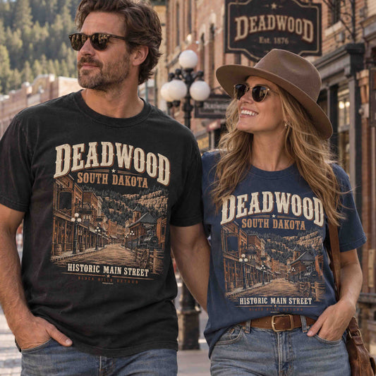 Couple wearing Deadwood South Dakota graphic tees featuring Historic Main Street, Black Hills scenery and Old West artwork