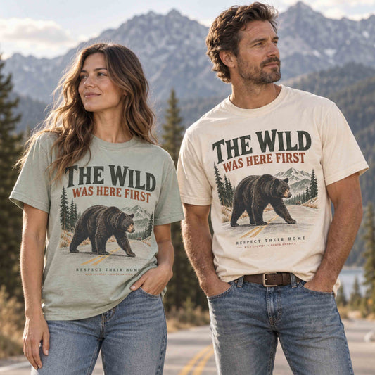 Couple wearing The Wild Was Here First bear wildlife graphic tees in Ivory and Bay outdoors in the mountains