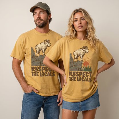 Comfort Colors graphic tee featuring a ram standing on a rocky cliff with pine trees, sunset artwork, and “Respect The Locals” text.