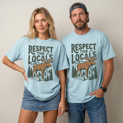 Comfort Colors graphic tee featuring a vintage moose, pine trees, mountain artwork, and “Respect The Locals” text.