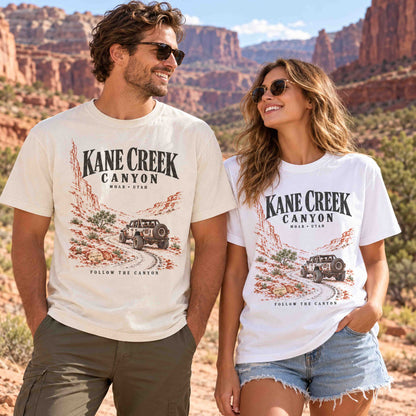 Man and woman wearing Ivory and White Kane Creek Canyon graphic tees in a Moab desert setting.