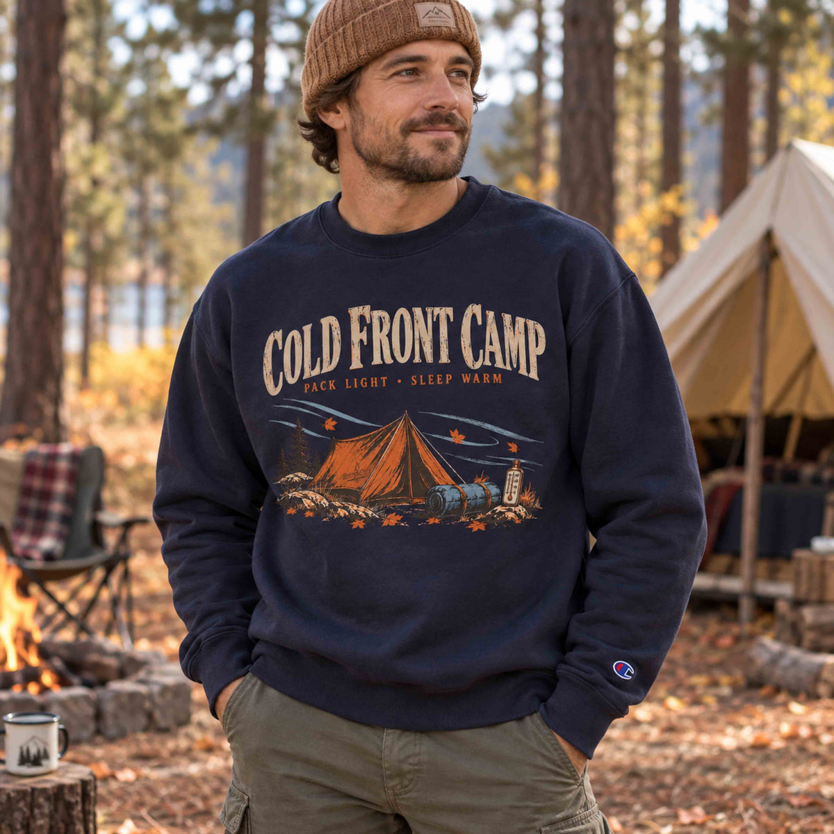 Woman wearing Navy Cold Front Camp unisex graphic sweatshirt at an autumn campsite, showing relaxed fit and front camping design