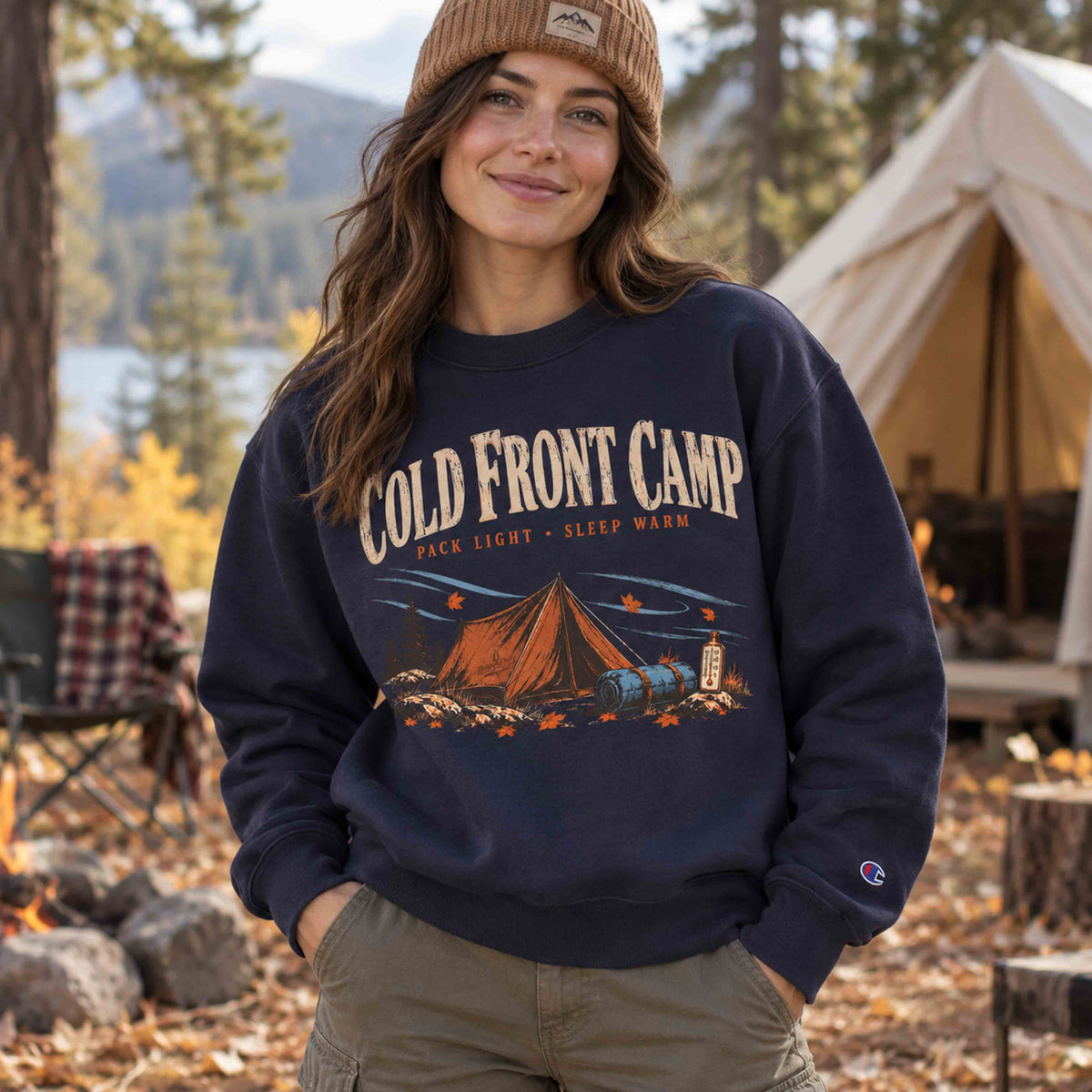 Woman wearing Navy Cold Front Camp unisex graphic sweatshirt at an autumn campsite, showing relaxed fit and front camping design