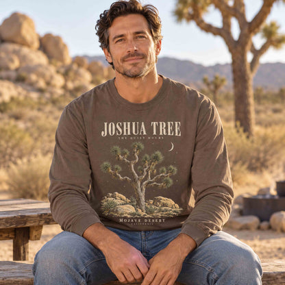 Man seated on a wooden bench wearing an Espresso Joshua Tree The Quiet Hours long sleeve shirt in a desert setting.