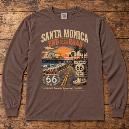 Espresso Santa Monica Route 66 long sleeve tee laid flat on wood, showing sunset, pier, palm tree and centennial artwork.