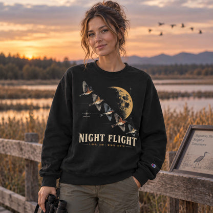 Birdwatcher wearing a Navy Night Flight Bird Migration Champion sweatshirt beside a marsh at golden hour