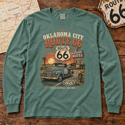 Light Green Oklahoma City Route 66 long sleeve tee laid flat on wood, showing vintage truck, motel sign and centennial artwork.