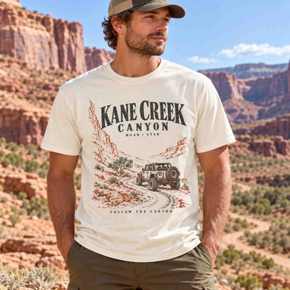 Man seated outdoors wearing the White Kane Creek Canyon graphic tee.