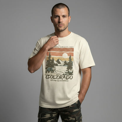 Front view of a man modeling a cream everyday-fit t-shirt with a retro Colorado mountain illustration.
