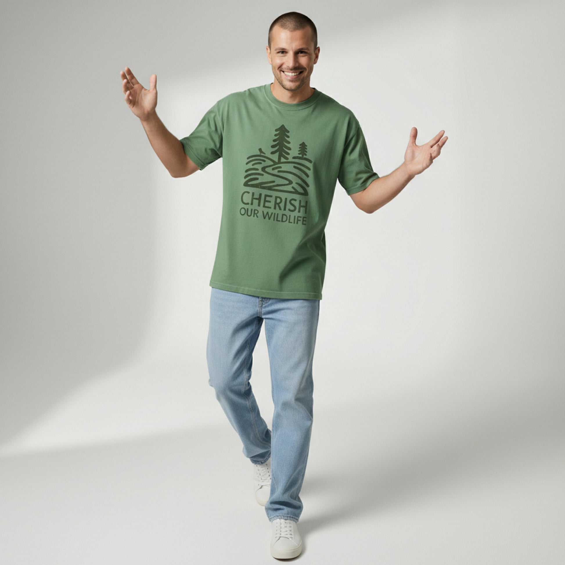Full body shot of a man walking forward and smiling, wearing a green "Cherish Our Wildlife" graphic tee and light blue jeans.