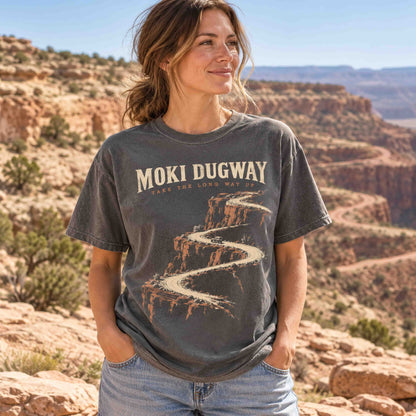 Woman wearing a Pepper Moki Dugway Utah graphic T-shirt against a canyon landscape.