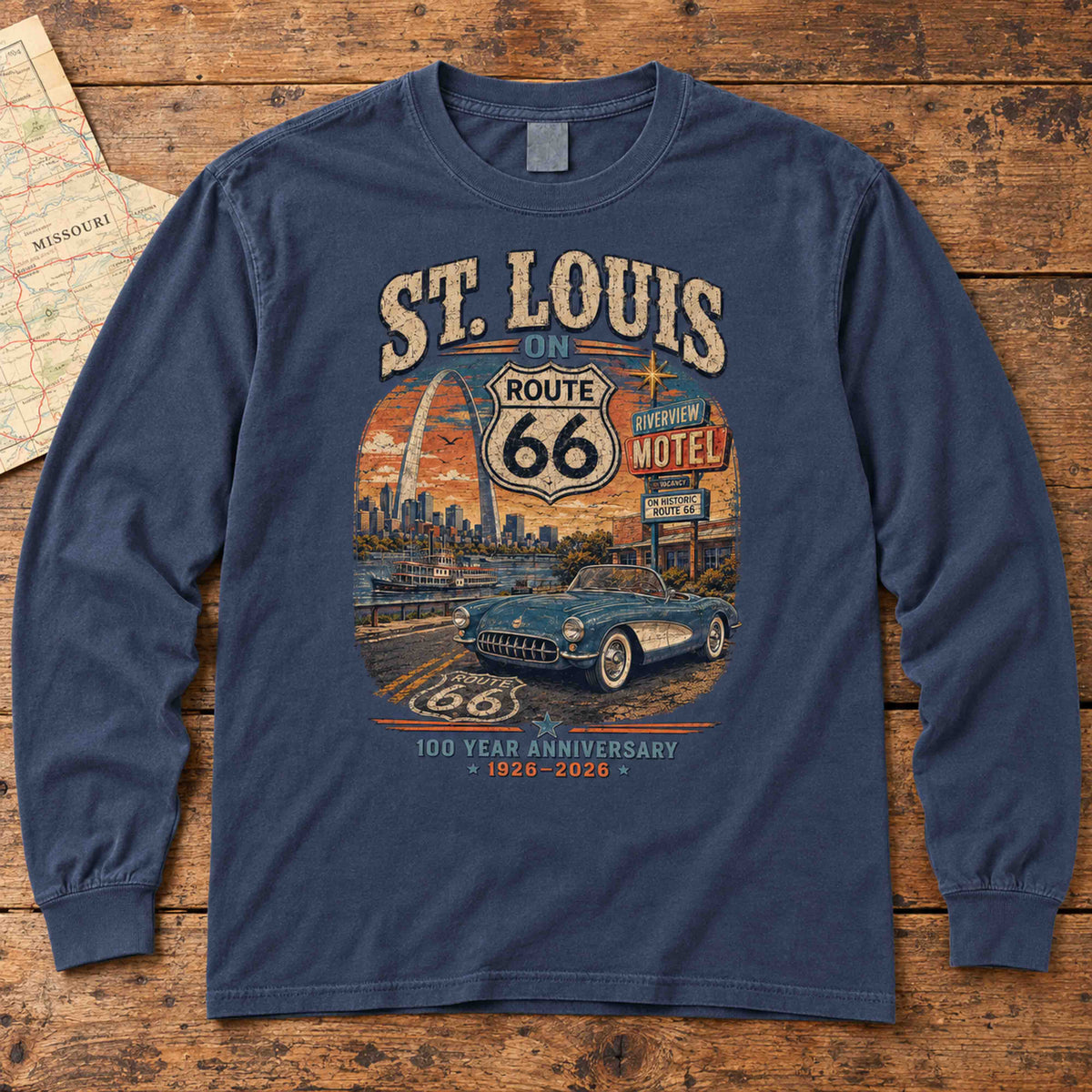 Navy St. Louis Missouri Route 66 long sleeve tee laid flat on wood, showing Gateway Arch, convertible and centennial artwork.
