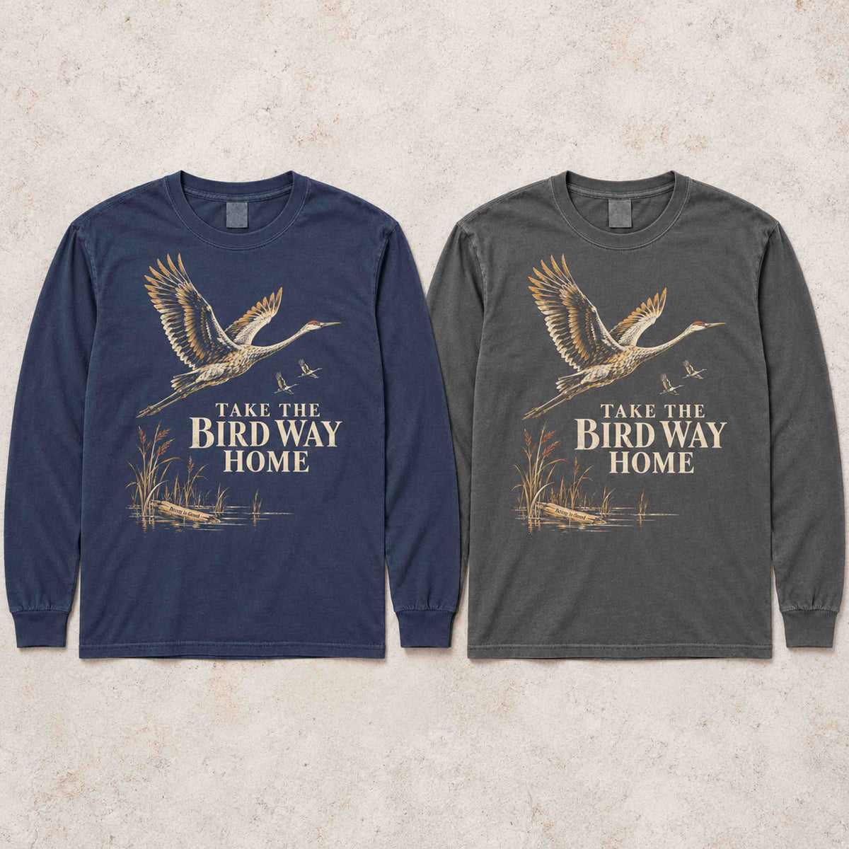 Navy and Pepper sandhill crane long sleeve shirts laid flat side by side.