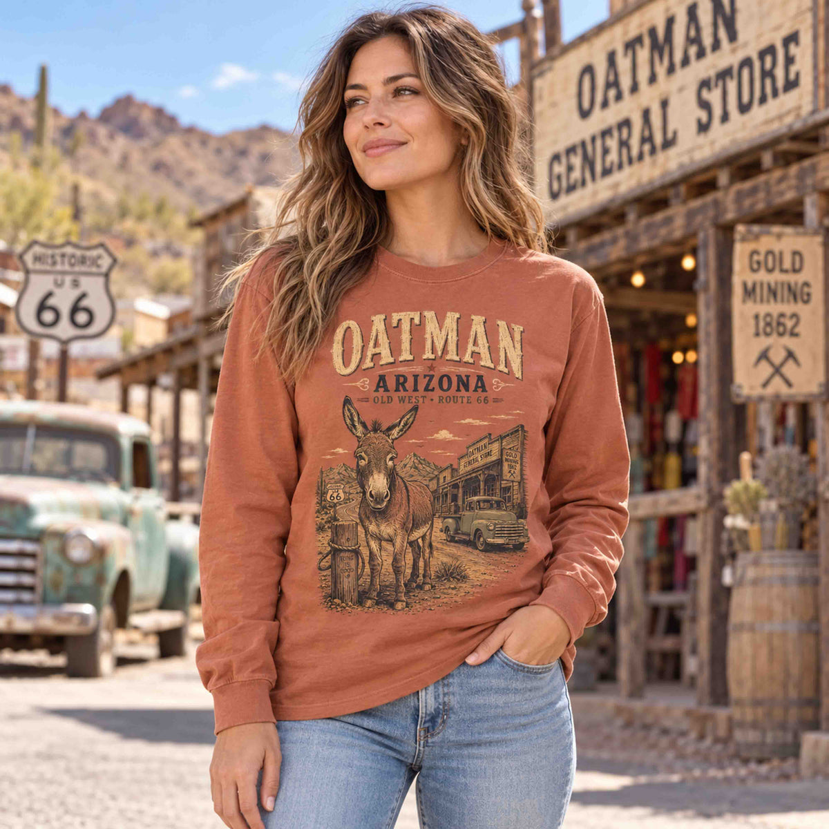 Woman wearing a Yam Oatman Arizona Route 66 long sleeve graphic tee outside a rustic storefront.