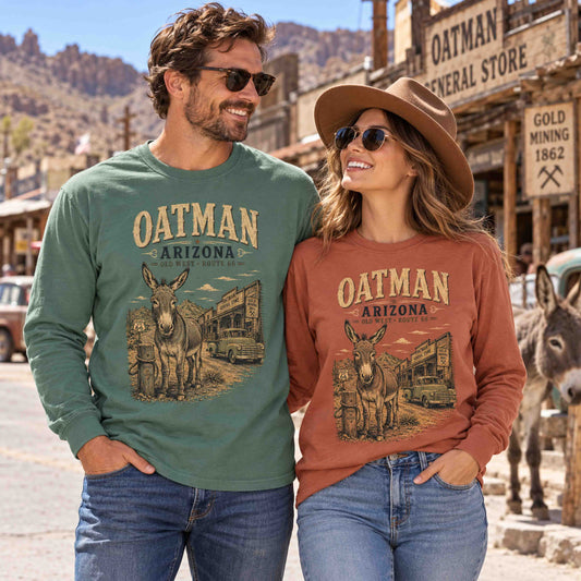 Man in Light Green and woman in Yam wearing Oatman Arizona Route 66 long sleeve tees with burro and vintage truck graphics.