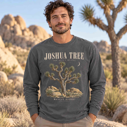 Man wearing a Pepper Joshua Tree The Quiet Hours long sleeve graphic shirt among desert trees and boulders.