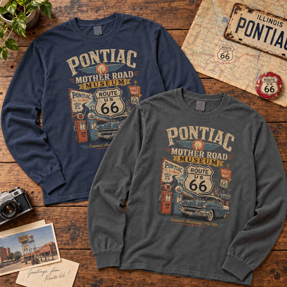 Navy and Pepper Pontiac Illinois Route 66 long sleeve graphic tees laid flat on wood beside a map and vintage camera.